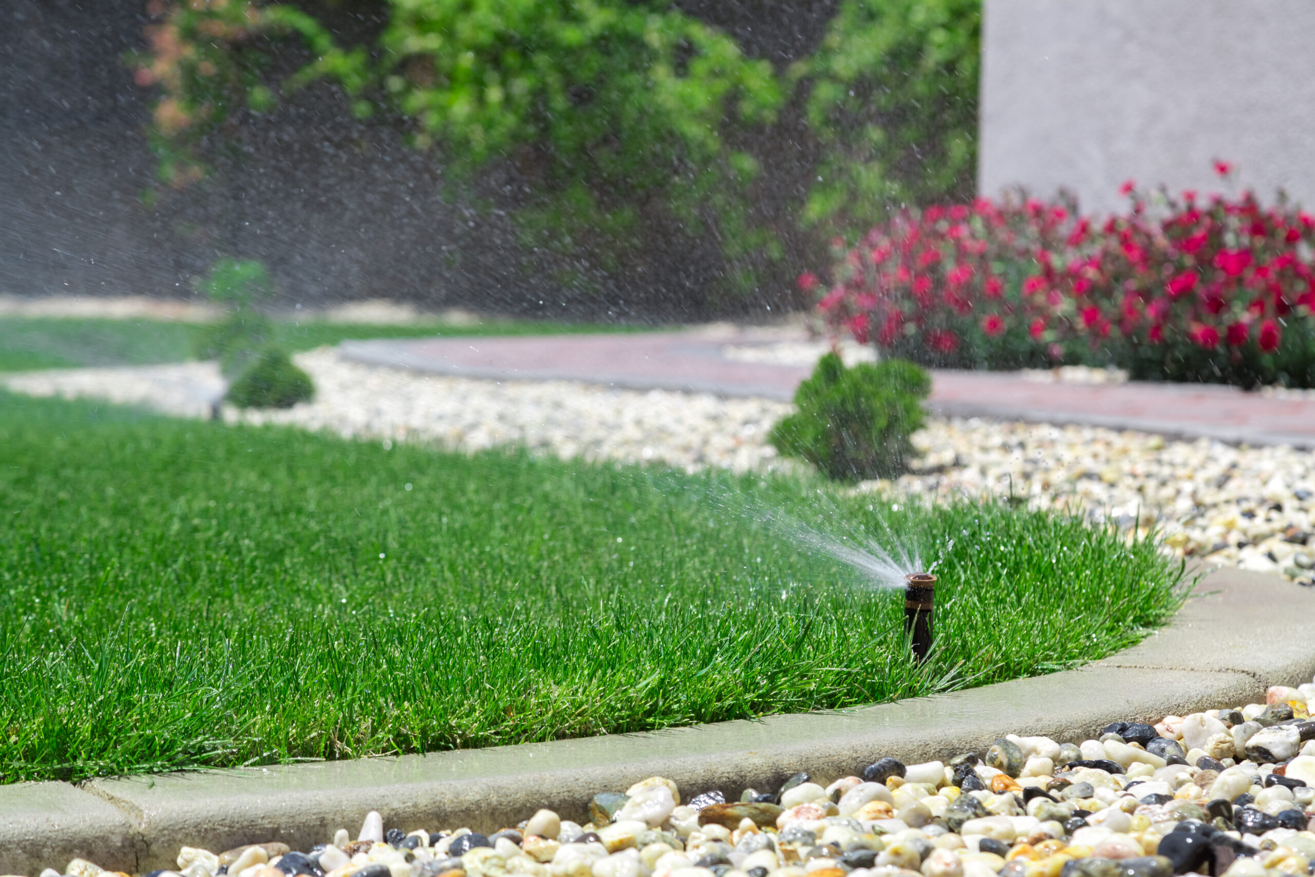 sprinkler system watering the grass of a residential or commercial lawn