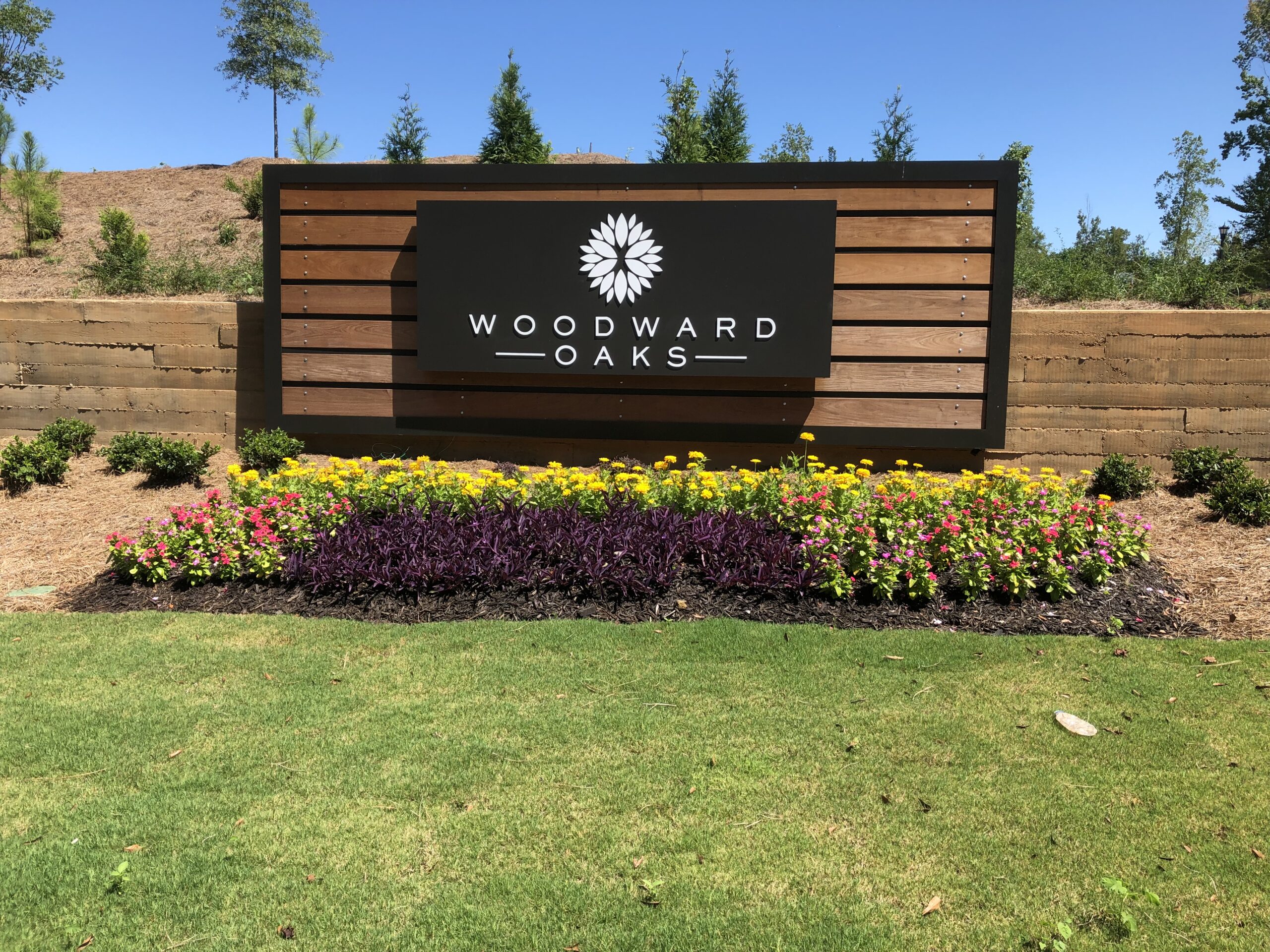 woodward oaks entry signage with flower beds and grass