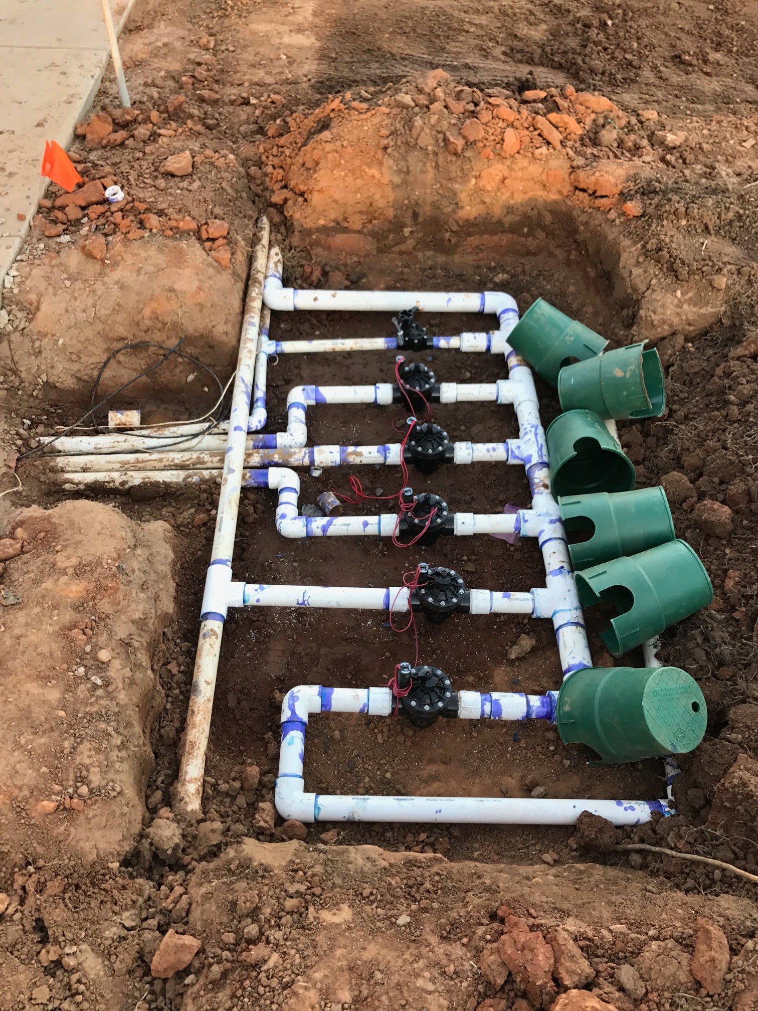view of pvc sprinkler piping irrigation system residential yard lawn maintenance landscaping